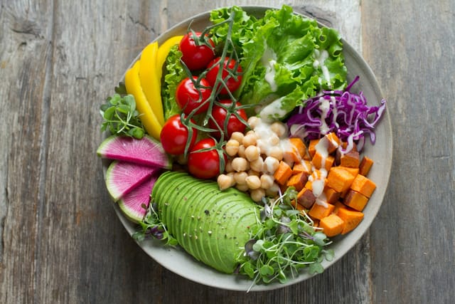 Un plato con verduras, legumbres y aguacate